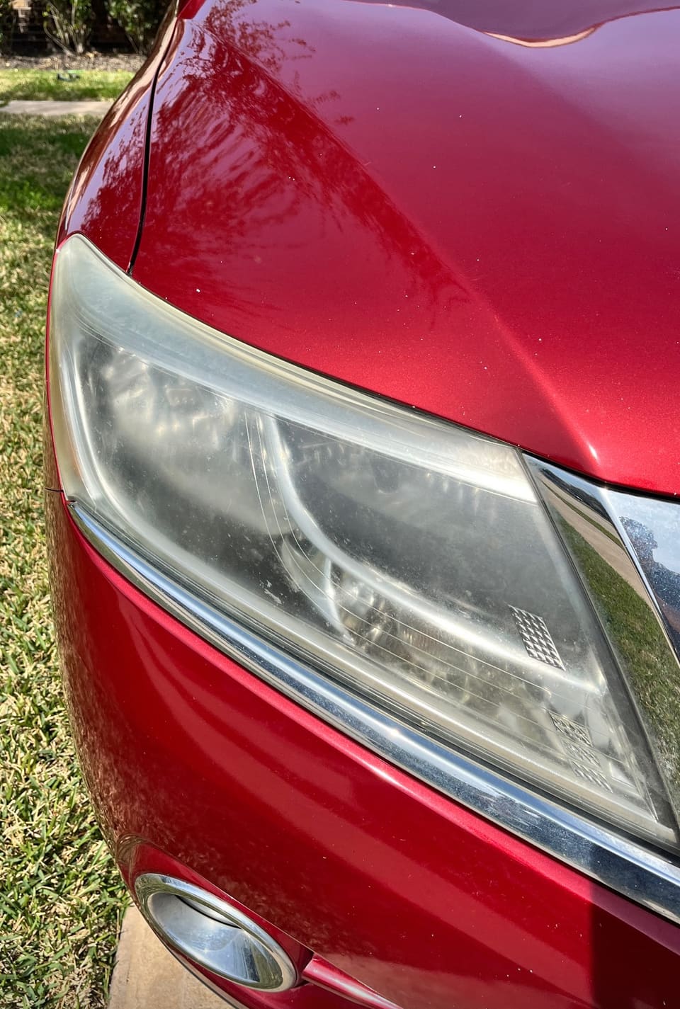 Restored headlight on a red car, close up